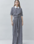 Gray wide-leg pantsuit and white shirtdress by SUNCOO in recycled polyester, styled on a plain neutral backdrop.