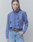 SUNCOO Lyes checked Victorian-style shirt in neutral tones, tucked into jeans with a brown belt.
