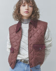 SUNCOO Djess maroon quilted sleeveless jacket with velvet collar, styled over a white sweater and blue jeans.