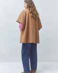 SUNCOO Ezra front-buttoned coat in pink with blue jeans, shown from the back against a light background.