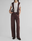 Rb Miramar terry track pull-on jeans, white t-shirt, and brown sweater draped over shoulders on a model.
