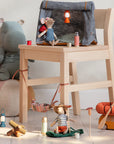 Maileg hiker mice with magnetic hands relax by a chair with camping gear, lanterns, and Thermos set; cozy adventure scene.