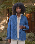 Eileen denim jacket in blue quilted diamond pattern worn over a cream button-down shirt.