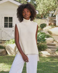Frank & Eileen Montecito Tank in white styled with white pants, worn outdoors in a sunny garden setting.