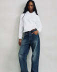 Denimist ALLFIT JEAN in classic denim, styled with a white hoodie, shown against a minimal background.