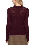 Brown plaid skirt and argyle polo sweater by Sea New York, seen from the back in a casual setting.