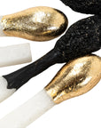 Oversized matchstick sculpture with metallic gold, matte black, and textured black heads by Bungalow Furniture.