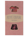 A pink Maileg box with window cutouts displays the Maileg Skirt & Knitted Blouse set—adorable little mouse clothes for stylish play.