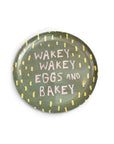 Serve your sunny side up Breakfast of Champions on Sugarboo Designs’ The Breakfast Club Plate Set—a round green plate with yellow dashes and “WAKEY WAKEY EGGS AND BAKEY” in pink and white.
