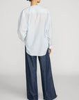 FRAME Offshore Pant in relaxed wide-leg fit, shown from the back with a loose blue striped shirt.