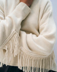 Oversized cream wool-cashmere sweater with braided trim and sleeve fringe from White + Warren.