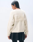 Oversized cream cashmere blend fringe crew sweater by White + Warren worn over a black skirt.