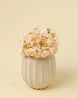 Cream ranunculus bouquet in a textured, ribbed ceramic vase by Bungalow Furniture & Accessories.
