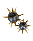 The Import Collection's Punk Candleholders feature metallic designs with multiple gold spikes. Displayed side by side on a white background, the bold gold spike candleholders come in two sizes, adding an edgy touch to any industrial decor.