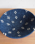 Round blue bowl with white patterns by Faire, displayed on a light wood surface for Bungalow Furniture & Accessories.