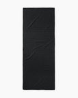 The Faire Chic Checker Yoga Towel, a rectangular, ultra-absorbent black towel with a plain design and subtle creases, is laid flat on a white background.