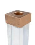 Square metallic bronze candleholder on a clear acrylic base by Bungalow Furniture & Accessories.