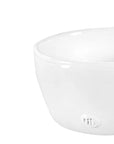 A close-up of the Montes Doggett L Bowl No. 222, a simple white high-fired ceramic bowl with a small embossed logo on the side, set against a plain background.