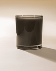Black Faire Herbituals herbal candle in clear glass, subtle shadow on white surface, Bungalow Furniture & Accessories.