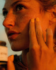 Faire SC Whipped Tallow Moisturizer being applied to a woman’s cheek with her fingers.