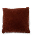 Velvet rust pillow with pom trim by Sugarboo Designs, decorative accent for living room or bedroom.