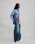 Denimist REMY BARREL JEAN and indigo denim shirt, worn sideways, set against a neutral gray background.