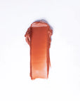 A rectangular swatch of Faire 01 Tinted Lip Balm & Blush, a creamy, reddish-brown hydrating formula, is smeared on a white background.