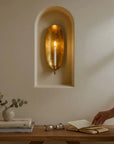 Brass wall candle sconce by Faire casts a warm glow above a cozy, styled wooden table at Bungalow Furniture & Accessories.