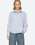 Sea New York Zayna Button Down shirt in light blue with layered hem and striped cuffs, styled with blue jeans.