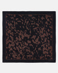 Black silk scarf with abstract brown animal print and thin border, by CLOSED, displayed on white background.