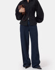 CLOSED Raglan Shirt and wide-leg blue jeans styled with black shoes and a brown clutch.