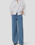 CLOSED embroidered shirt with wide-leg blue jeans featuring wavy seams, shown hands in pockets.