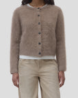 CLOSED crew neck cardigan in beige, layered over white shirt and jeans, modern casual style.