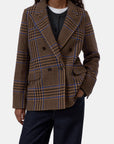 Sand beige fitted double-breasted blazer by CLOSED styled with black shirt, white tee, and dark jeans.