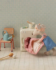Maileg Hiker Mouse in blue dress loading a mini washer, with charming laundry accessories beside her.