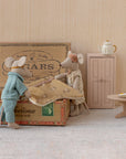 Maileg Mum & Dad Mice in a cigar box bed—one wears pajamas, the other a dress and bow. Nearby are a small cabinet, round table with teapot and cake, and a tiny wooden stool. All by Maileg.