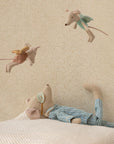 The Maileg Medium Mouse, Pyjamas by Maileg rests on a pillow, looking up at two fairy mice, creating a charming bedtime scene perfect for any child's room.