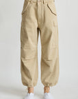Denimist cropped cargo pants with utility pockets and drawstring ankles styled with white sneakers on neutral backdrop.