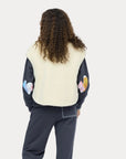 Kerri Rosenthal Coze Magoze Vest and dark patchwork-sleeve pants, shown from the back on a person with curly hair.