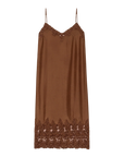 The Legacy Dress by The Great Inc. is a vintage-inspired brown satin slip dress with spaghetti straps, embroidered mesh lace trim at the neckline, and matching lace detailing at the hem.