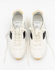 A pair of white Essex Sneakers from ONCEPT, ultra-lightweight with black side stripes and yellow accents, are shown from above. Both shoes are unlaced, revealing the ONCEPT label on the tongue and outward-spread laces.