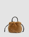 Tan shearling drawstring pouch with black leather handle and side cords by Clare Vivier.