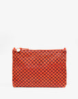 Clare Vivier's "Flat Clutch w/ Tabs" is shown against a plain white background. The red, handwoven leather clutch bag features a checkered pattern and a top zipper with a round pull, combining style and functionality seamlessly.