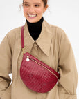 Clare Vivier Grande Fanny S26 handwoven leather crossbody with gold zipper, worn with a tan trench coat.