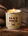 Faire Hay Ride soy candle by Bungalow Furniture on wood with a leaf and burlap sack for a cozy autumn accent.