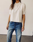 The Boxy Polo in Natural by Hey Gang paired with blue jeans, minimalist style against a simple backdrop.