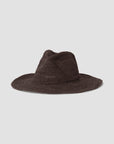 The Sacha Hat by Janessa Leone is a wide-brimmed, dark brown Madagascar straw hat with a slightly creased crown, shown on a plain light gray background.