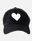 The KR Imperfect Heart Hat by Kerri Rosenthal is a black baseball cap with a large embroidered heart patch on the front, shown against a plain light gray background.