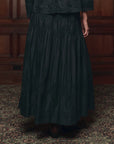Pleated Victorian-style Lattice Lace skirt by The Great Inc., patterned detail, shown with wood panel backdrop.