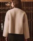 Woodside Toggle Coat by The Great Inc. in a relaxed style, shown near ornate gold gates with hair down.